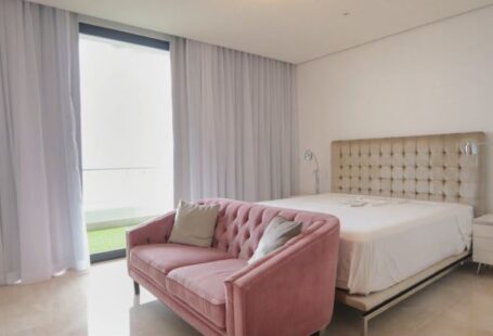 Sofa Bed - A bedroom with pink furniture and a large window