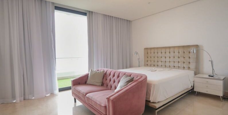 Sofa Bed - A bedroom with pink furniture and a large window