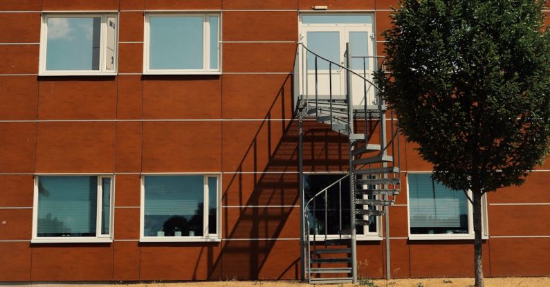 Staircase Designs - A tree is in front of a building with stairs
