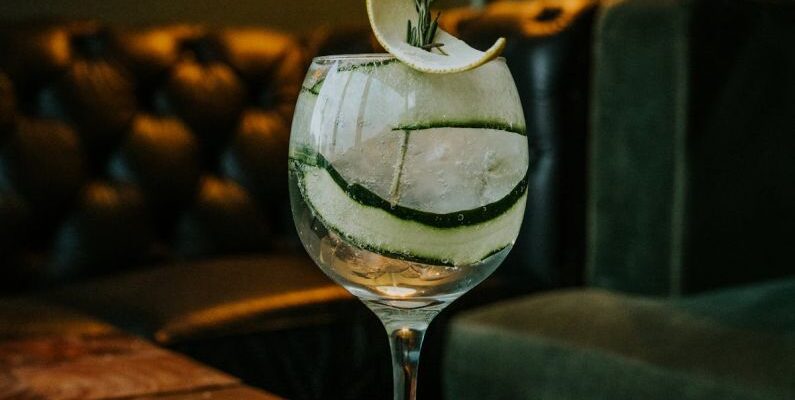 Modular Sofas - A gin and tonic on a wooden table with a slice of cucumber