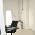 Loft Apartment - Interior of spacious loft studio with meeting table and chairs surrounded by hanging white curtains