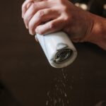 Spice Storage - Person in Blue Denim Jacket Holding White Ceramic Mug