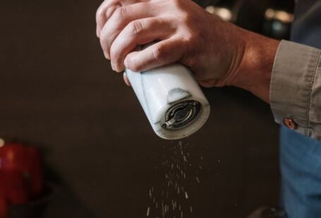 Spice Storage - Person in Blue Denim Jacket Holding White Ceramic Mug