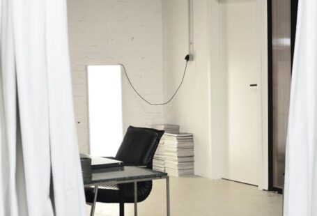 Loft Apartment - Interior of spacious loft studio with meeting table and chairs surrounded by hanging white curtains