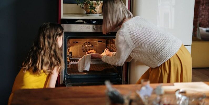 Oven - Woman in White Sweater Baking Cake