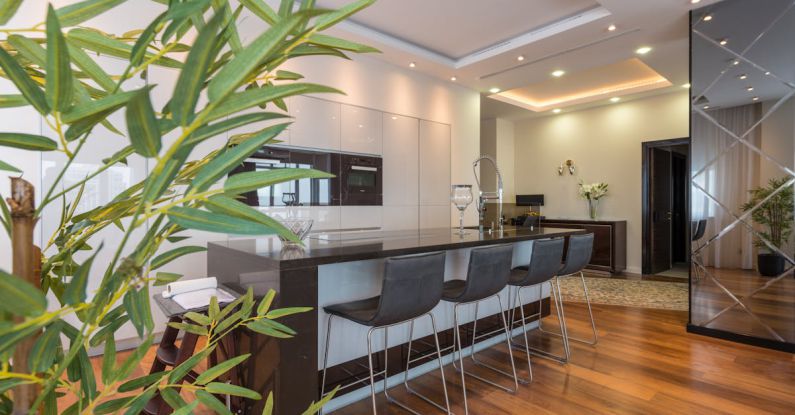 Built-In Shelves - Kitchen island with black leather chairs in spacious modern apartment with white minimalist furniture and built in appliances