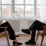 Loft Conversion - Person in Black Pants and Black Shoes Sitting on Brown Wooden Chair