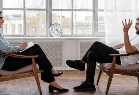 Loft Conversion - Person in Black Pants and Black Shoes Sitting on Brown Wooden Chair