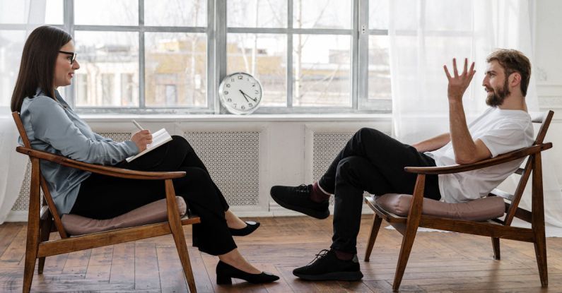 Loft Conversion - Person in Black Pants and Black Shoes Sitting on Brown Wooden Chair