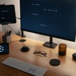 Smart Speakers - Computer with various electronic devices and speaker placed on table