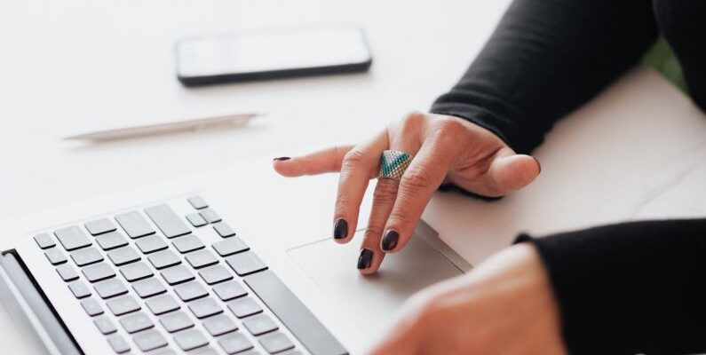 Smart Blinds - Crop female using touchpad on laptop in office